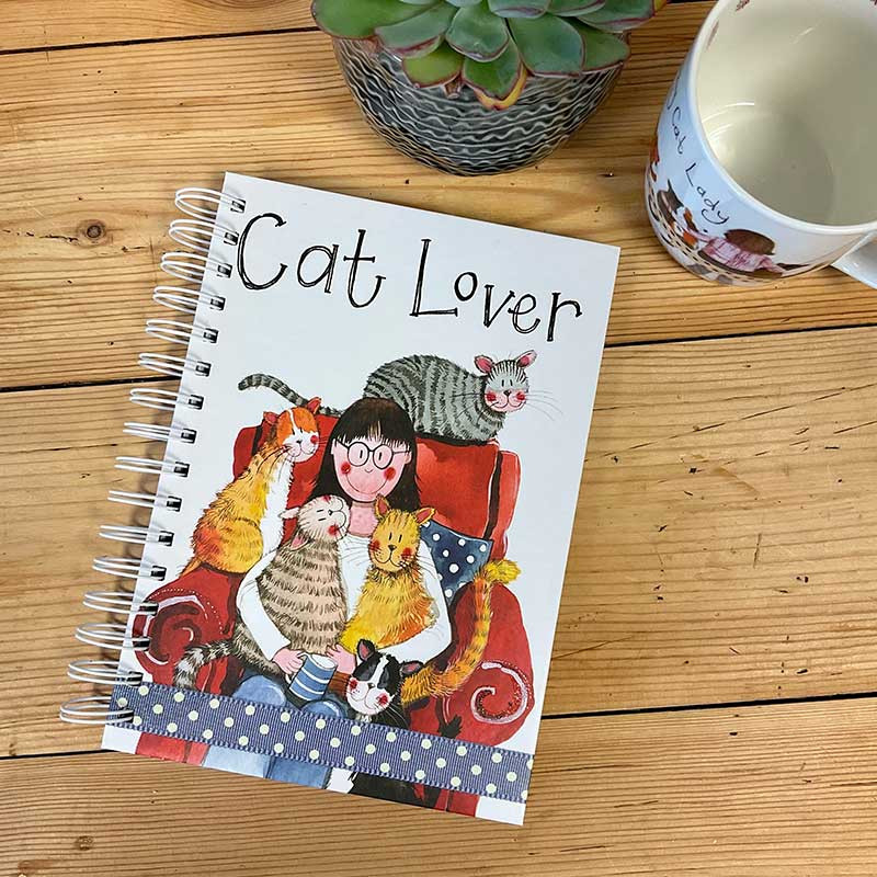 Forward facing lifestyle image of Alex Clark Cat Lover Spiral Journal. Featuring a lady and her five cats.